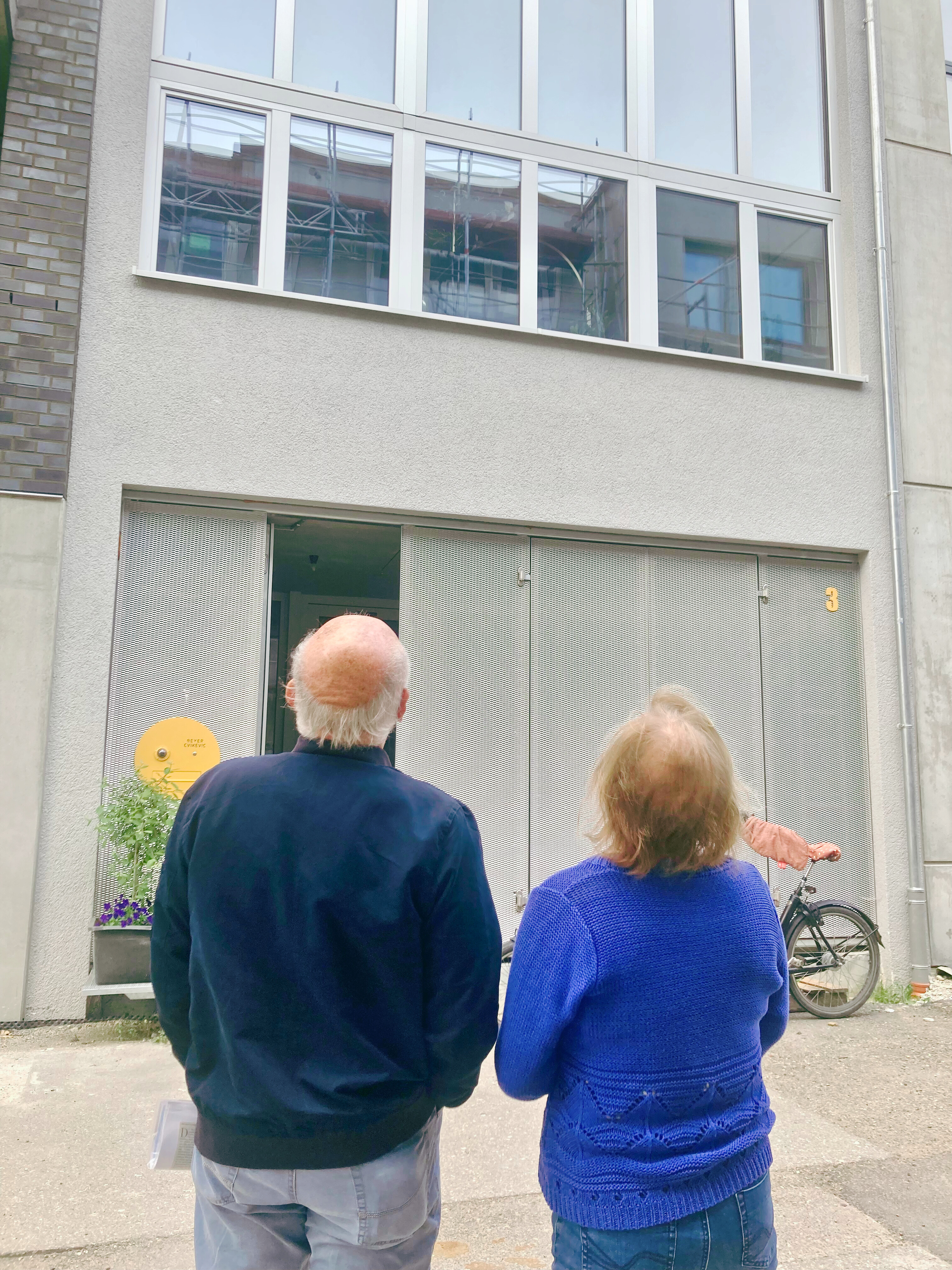 Zwei Menschen blicken auf ein Gebäude